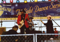 Bo Diddley and an unidentified guitarist and drummer performing at the Santa Monica Pier Twilight Dance Series, July 9, 1998 [descriptive]