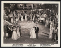 Deanna Durbin and Robert Paige surrounded by cast members in a scene from Can't Help Singing