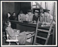 Lauren Bacall, Charles Boyer, and servicemen on the set of Confidential Agent