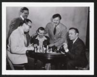 Argentinian chess Master Herman Pilnik plays a game with actor Charles Boyer on the set of Confidential Agent