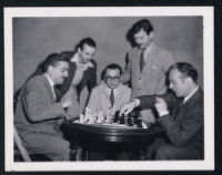 Charles Boyer and and several chess players on the set of Confidential Agent