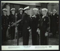 William Bendix and Groucho Marx are awarded medals as extras look on in a Girl in Every Port