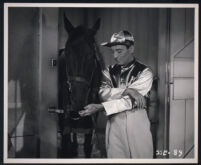 George E. Stone feeding a horse in a scene from A Girl in Every Port
