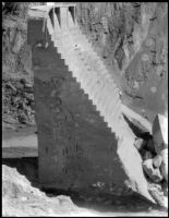 Side view of "The Tombstone", a slab of the St. Francis Dam visible after its disastrous collapse, San Francisquito Canyon, 1928