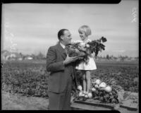 Linton H. Smith, organizer of the community gardens project, poses with local girl during harvest.  February 1934.