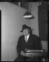 E.V. Durling, newspaper columnist, poses by typewriter, Los Angeles, 1930s
