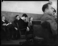 Louis Payne sits and bows head in a courtroom, Los Angeles, June-July, 1934