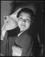 Miss Lil Tokio Alice Watanabe poses with a fan in a traditional kimono in honor of the Nsei festival, Los Angeles, 1935