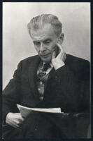 Aldous Huxley seated and reading, hand on cheek [descriptive]
