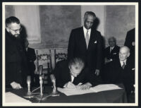Aldous Huxley signing document at the Food and Agriculture Organization of the United Nations Conference, Rome 1963 [descriptive]