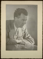 Aldous Huxley portrait, profile, at desk leaning on arms, wearing tweed blazer, in writing studio, Llano CA [descriptive]