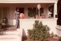 Girl on porch with pumpkin
