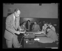 Roger Otis demonstrates a recording device at the trial of Jack Santo, Emmett Perkins, and Barbara Graham, Los Angeles, 1953