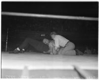 Referee on top of Ali Baba who is on top of his opponent Jules Strongbow during a wrestling match, Los Angeles, July 28, 1937