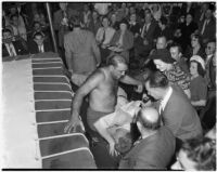 Wrestler King Chewaki falling out of the ring onto referee Dick Rutherford at Olympic Audiorium, Los Angeles, circa 1937