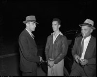 Former Marine Nelson D. Boyer with two policemen after confessing to his wife's murder and identifying the place where he buried her body, South Gate, October 26, 1937