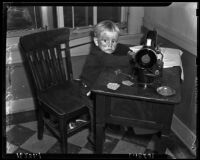 Young boy stands by a sewing machine, Los Angeles, 1925-1945