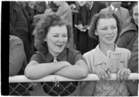 Two young women watch the races on opening day of Santa Anita's fourth horse racing season, Arcadia, December 25, 1937