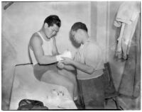 Ceferino Garcia, champion boxer from the Philippines, getting his hand wrapped by a trainer, Los Angeles, circa 1938