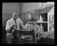 Psychologist Dr. Alan Glasser treats a young boy, Los Angeles, 1955