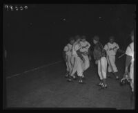 Angels baseball team players on the field at night, Los Angeles, 1956