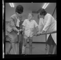 John Marcum, 9, being aided by doctors during hemophilia rehabilitation, 1965.