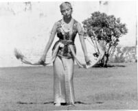 A full-length shot of a young woman dancing in costume