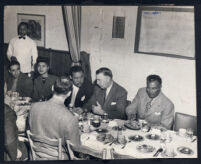 Joe Louis seated at restaurant table with Muriel Andrade, Dick Abrams and others, Los Angeles 1940s