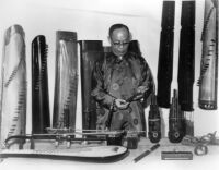 Professor Liang Tsai-ping examining instruments to be used in the performance of Shantung traditional music