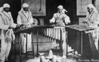 Photo of four men playing Marimba