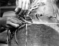 Using a thin bamboo needle threaded to the rope a man is sowing rope into the membrane