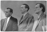 Murder suspect Robert S. James standing between two unidentified men in court, Los Angeles, 1936