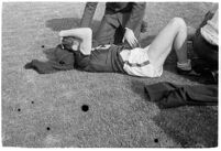 USC track athlete lying on the Coliseum field while being examined, Los Angeles, 1937