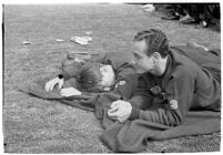 Two USC track athletes lying on a blanket at the Coliseum, Los Angeles, 1937