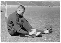 USC track athlete taping his foot on the field, Los Angeles, 1937