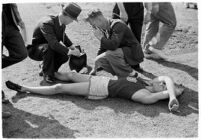 Sports officials examining a USC track athlete for injury, Los Angeles, 1937