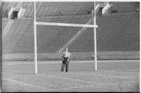 Photographer on the Coliseum field during a game between the Loyola Lions and the Galloping Gaels of St. Mary's, Los Angeles, 1937