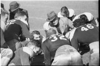 Loyola Lions in a huddle with their coaches on the Coliseum field, Los Angeles, 1937