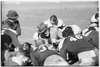 Loyola Lions in a huddle with their coaches on the Coliseum field, Los Angeles, 1937