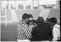 Loyola Lions' coach Tom Lieb and referees with player, during game against Santa Clara's Broncos at the Coliseum, Los Angeles,  1937