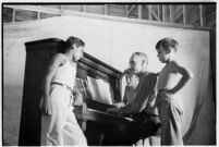 Boys gathered around piano and pianist, taking part in a free summer camp organized by Los Angeles Sheriff Eugene Biscailuz.  Circa July 1937.