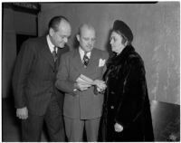 Attorney R. M.  Trezevant reading a piece of paper with Carl and Ruby Crockett, Los Angeles