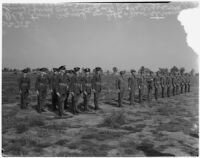 Soldiers in old military uniforms stand next to others wearing the new "streamlined" style during a military show for National Defense Week, Los Angeles, 1940