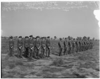 Soldiers in old military uniforms stand next to others wearing the new "streamlined" style during a military show for National Defense Week, Los Angeles, 1940