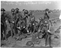 Soldiers change from hats to helmets during a military show for National Defense Week, Los Angeles, 1940