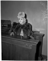 Mae West sitting in court during questioning about earnings from her role in the movie 