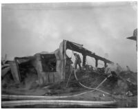 Firefighter walks through the ruins of a fire that occurred at Dura Steel Products Co., Los Angeles, 1940