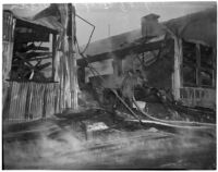 Firefighters walk through the ruins of a fire that occurred at Dura Steel Products Co., Los Angeles, 1940