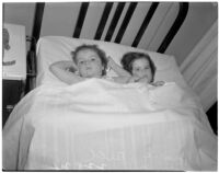 Young girls Barbara and Rosalie Bell laying next to each other in a twin-sized bed, Los Angeles
