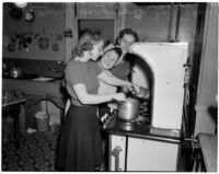 Three USC sorority sisters cook by a stove, Los Angeles, 1940